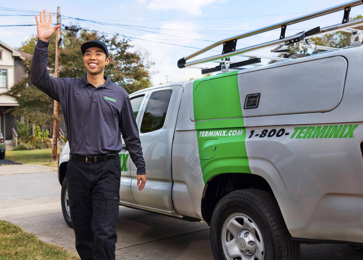An image of a Terminix employee next to a Terminix-branded van. 