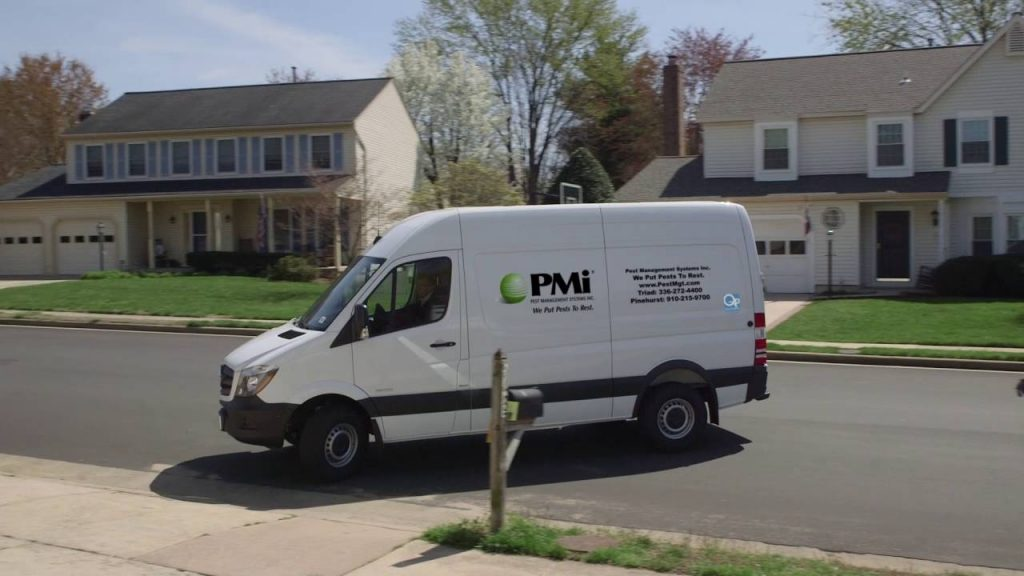 PMi service van with company logo parked on a residential street in a Piedmont Triad neighborhood.