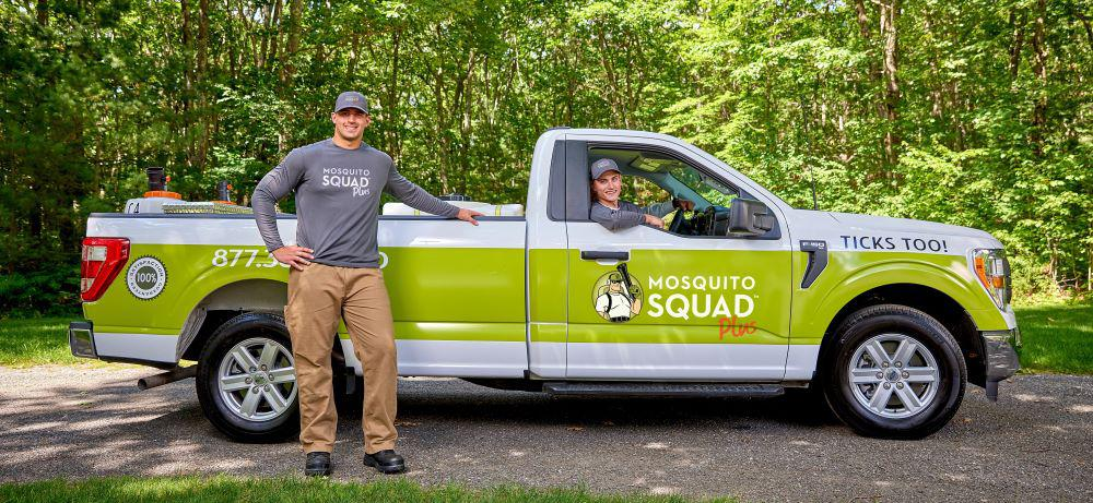 Two Mosquito Squad of the Triad technicians with their branded green and white service truck, ready for mosquito and tick treatment.