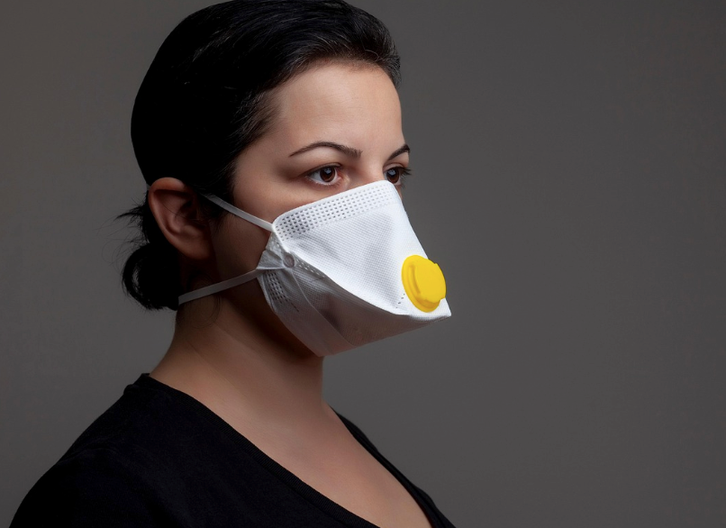 A person wearing a mask as she prepares to clean up bird and bat droppings. 