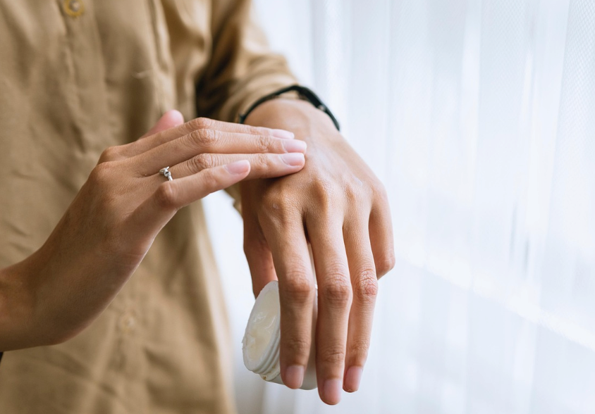 A person applying a hydrocortisone cream to relieve itching caused by a tick bite