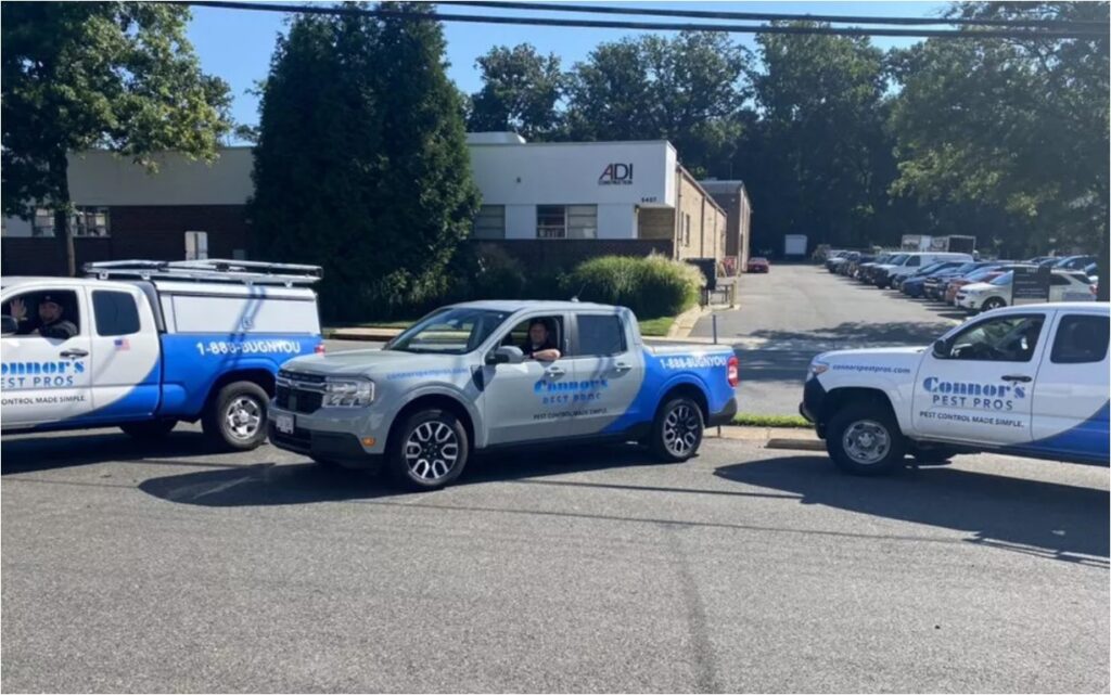 Three Connor's Pest Pros service trucks are parked in a lot, ready for pest control appointments. 