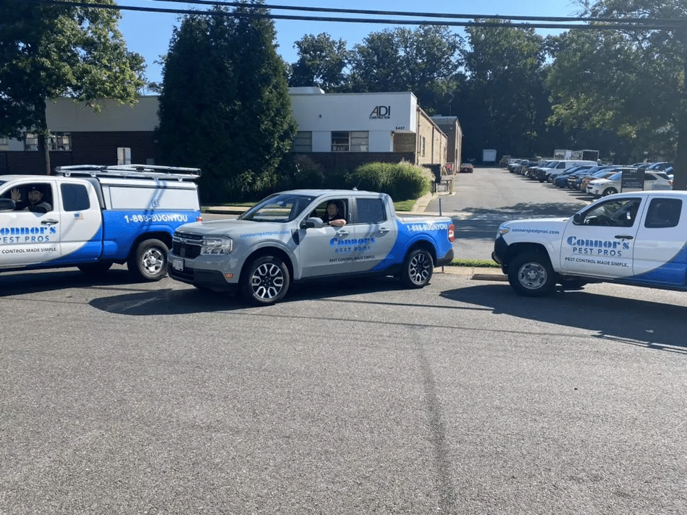 Three Connor's Pest Pros trucks marked "1-888-BUGNYOU" and "PEST CONTROL MADE SIMPLE." ready for service calls.